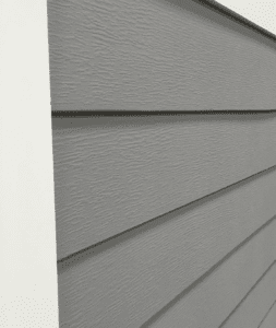 A close up of a gray siding on a wall.